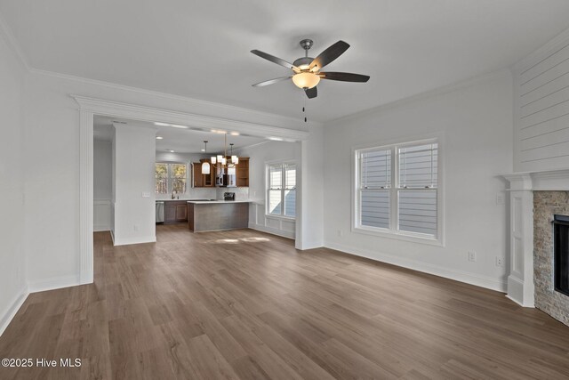 unfurnished living room with a fireplace, ornamental molding, and dark wood-style flooring