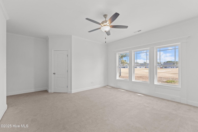 carpeted empty room with visible vents, ornamental molding, ceiling fan, and baseboards