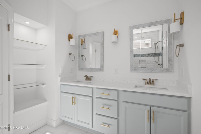 full bathroom featuring double vanity, marble finish floor, a tile shower, and a sink