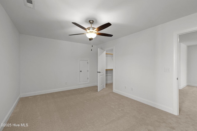 unfurnished bedroom with ceiling fan, light carpet, visible vents, baseboards, and a spacious closet