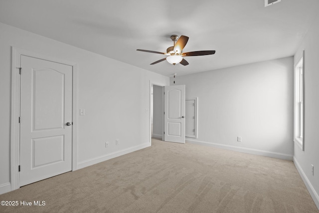 carpeted empty room featuring visible vents, baseboards, and a ceiling fan