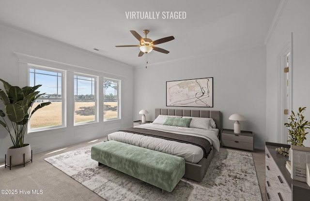 carpeted bedroom featuring ornamental molding, visible vents, and a ceiling fan