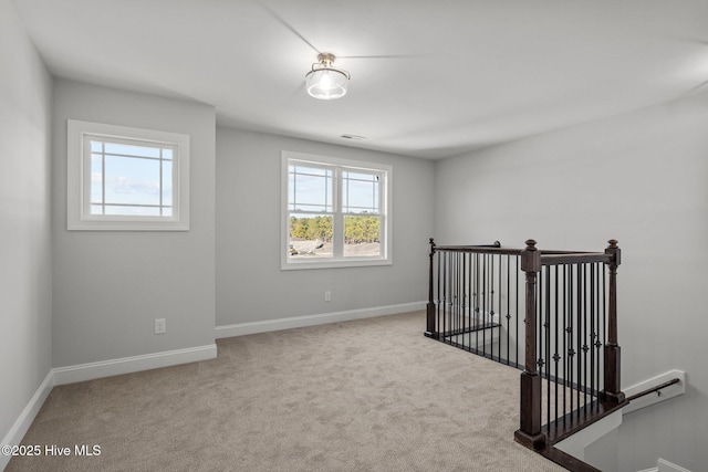 carpeted empty room with baseboards