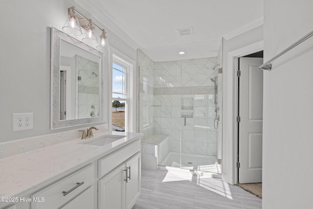 bathroom with a stall shower, vanity, and visible vents