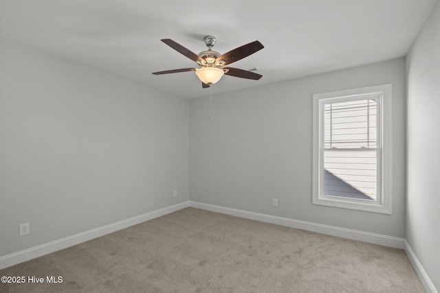 carpeted spare room with ceiling fan and baseboards