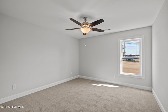 empty room with carpet floors, ceiling fan, and baseboards