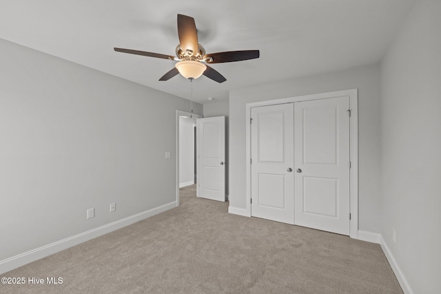 unfurnished bedroom featuring carpet floors, a closet, a ceiling fan, and baseboards