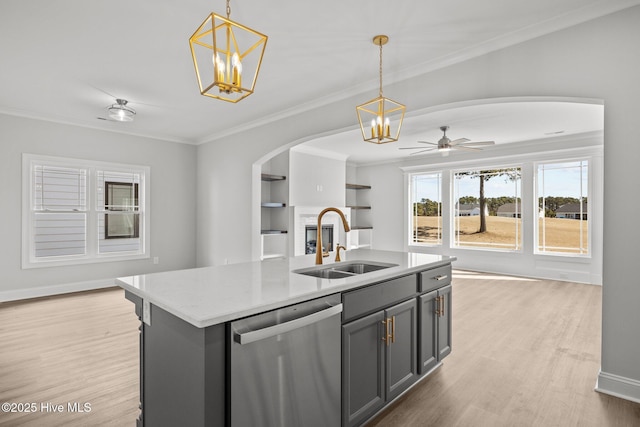 kitchen with arched walkways, a sink, light wood-style floors, open floor plan, and dishwasher