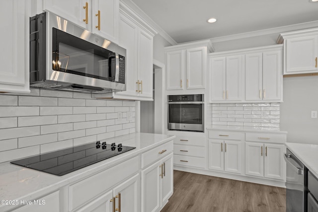 kitchen with stainless steel appliances, wood finished floors, white cabinetry, and crown molding