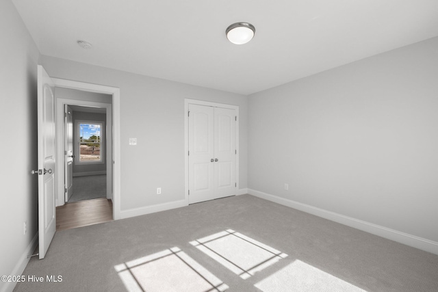 unfurnished bedroom featuring carpet floors, a closet, and baseboards