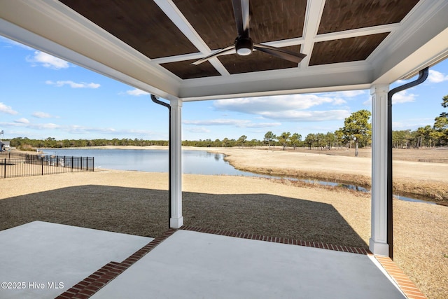 view of patio with a water view, ceiling fan, and fence