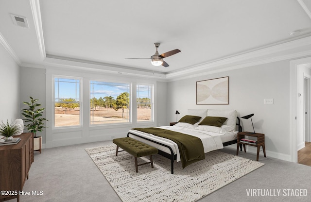 bedroom featuring light carpet, visible vents, ornamental molding, and a raised ceiling