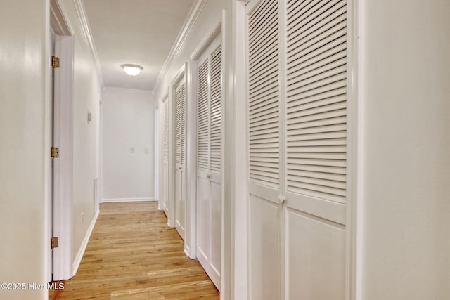 hallway with ornamental molding and light wood-type flooring