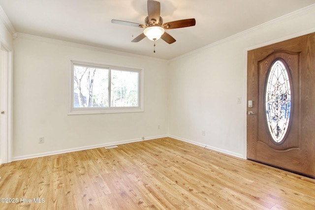 entrance foyer featuring ornamental molding, a healthy amount of sunlight, and light hardwood / wood-style flooring