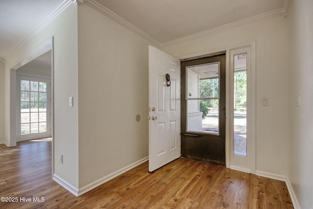 entryway featuring ornamental molding and light hardwood / wood-style flooring