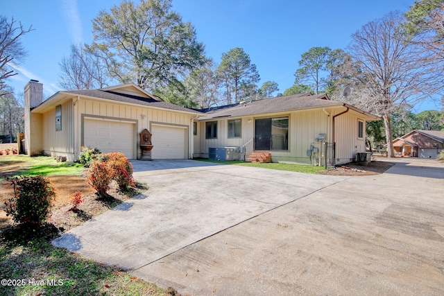 37 Carolina Shores Dr, Calabash, NC 28467 - single story home featuring board and batten siding, concrete driveway, an attached garage, a chimney, and a shingled roof