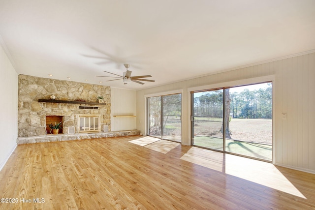 unfurnished living room with hardwood / wood-style floors, a wealth of natural light, a fireplace, and ceiling fan