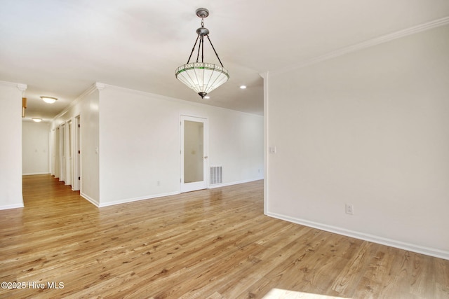 spare room with crown molding and light hardwood / wood-style floors