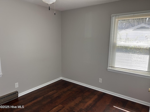 613 Sexton Ave, Zebulon, NC 27597 - spare room featuring a baseboard radiator, baseboards, a healthy amount of sunlight, and wood finished floors