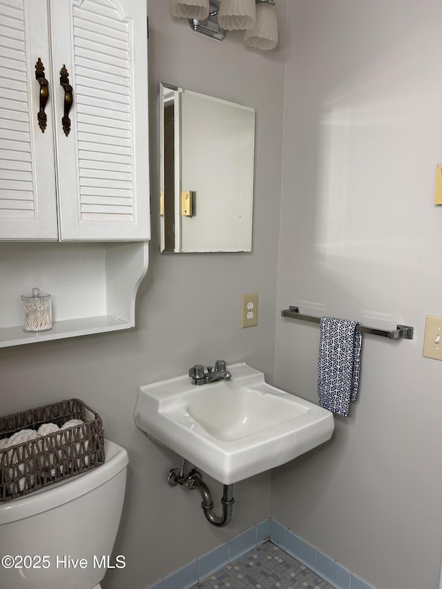 613 Sexton Ave, Zebulon, NC 27597 - half bathroom with baseboards, toilet, and a sink