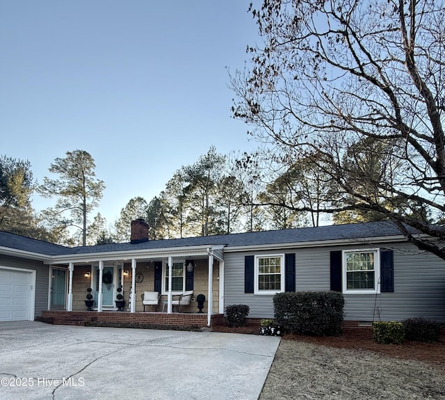 ranch-style home featuring a garage and covered porch