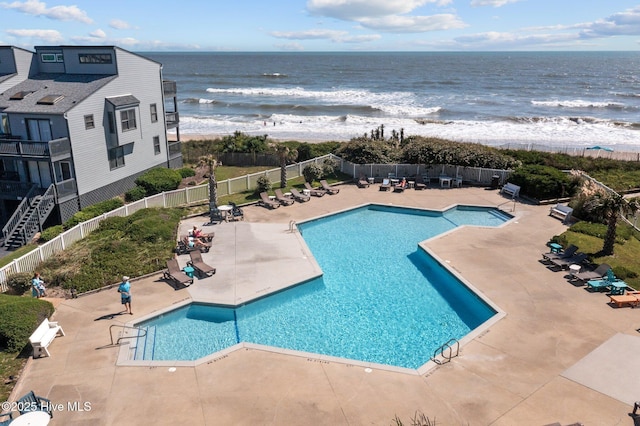 view of pool with a patio area and a water view