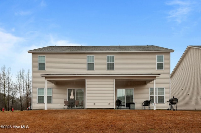 back of property featuring a patio and a lawn