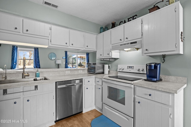 1810 Paulette Rd, Morehead City, NC 28557 - kitchen with stainless steel dishwasher, white electric stove, under cabinet range hood, a sink, and light countertops