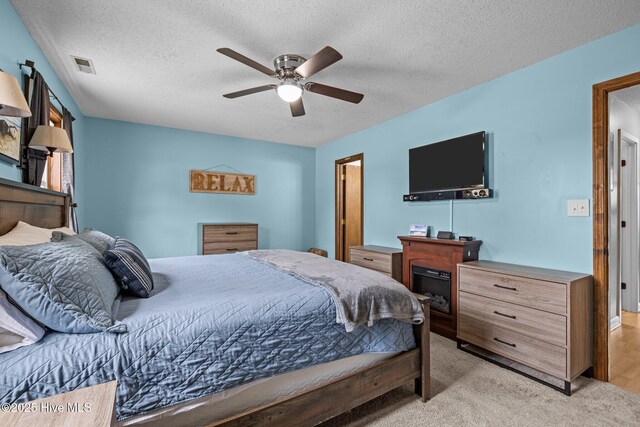1810 Paulette Rd, Morehead City, NC 28557 - bedroom featuring a textured ceiling, light carpet, and ceiling fan