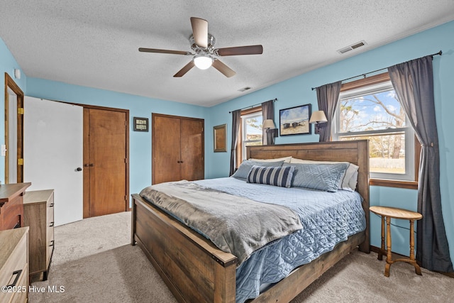 1810 Paulette Rd, Morehead City, NC 28557 - bedroom with carpet floors, multiple closets, a textured ceiling, and a ceiling fan