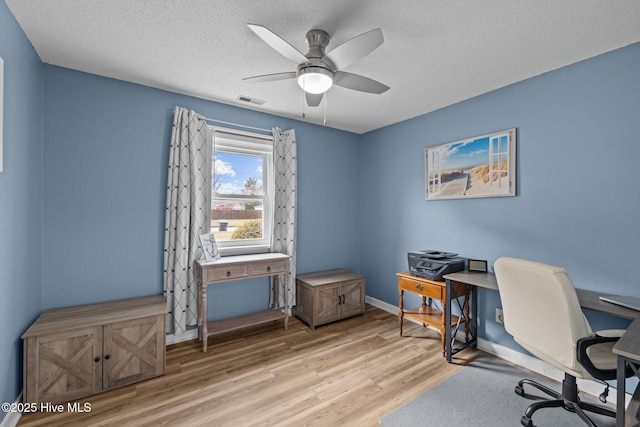 1810 Paulette Rd, Morehead City, NC 28557 - home office featuring light wood-type flooring, a ceiling fan, a textured ceiling, and baseboards