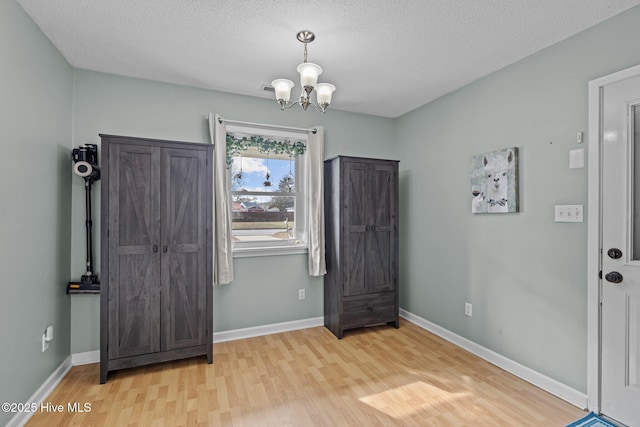 1810 Paulette Rd, Morehead City, NC 28557 - entryway with wood finished floors, a chandelier, a textured ceiling, and baseboards