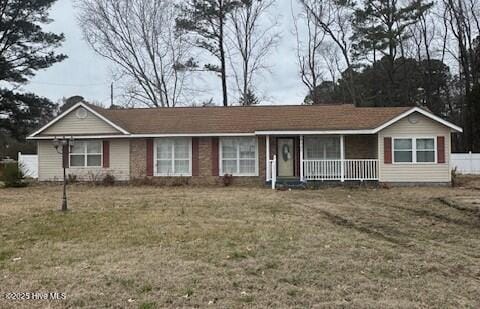 ranch-style house with a front yard and covered porch