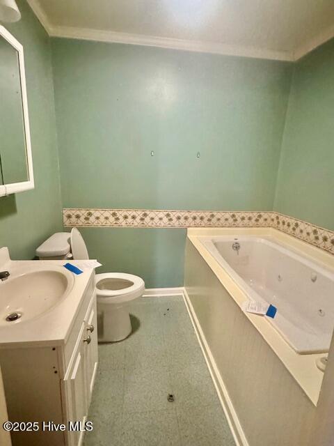 bathroom featuring vanity, a bath, ornamental molding, and toilet