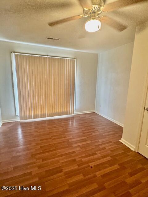 unfurnished room featuring hardwood / wood-style flooring, ceiling fan, and a textured ceiling