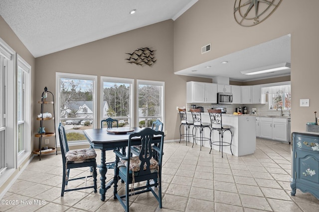 806 Lord Granville Dr, Morehead City, NC 28557 - dining room with high vaulted ceiling, a textured ceiling, recessed lighting, and baseboards