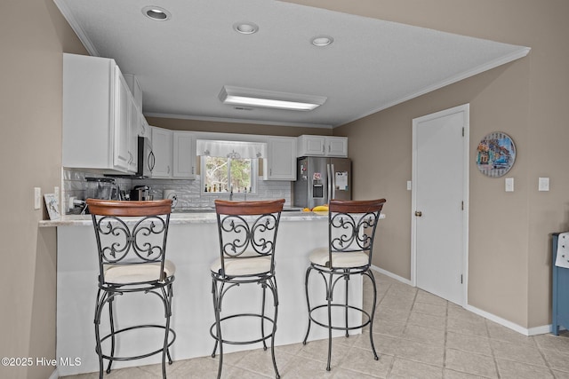806 Lord Granville Dr, Morehead City, NC 28557 - kitchen featuring stainless steel appliances, a peninsula, ornamental molding, a breakfast bar area, and light countertops