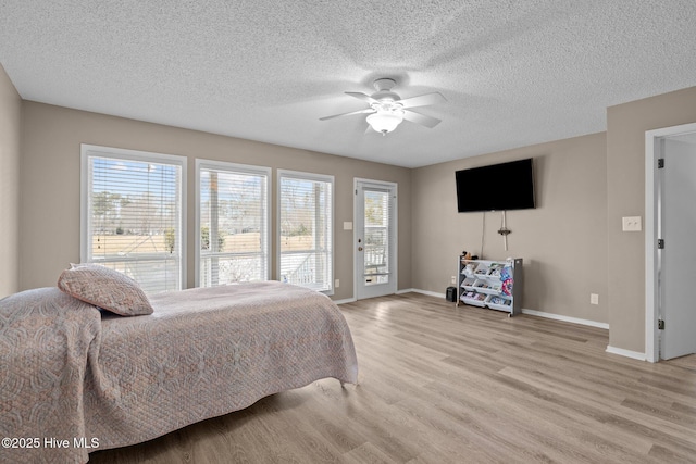 806 Lord Granville Dr, Morehead City, NC 28557 - bedroom featuring access to outside, light wood-type flooring, baseboards, a textured ceiling, and a ceiling fan
