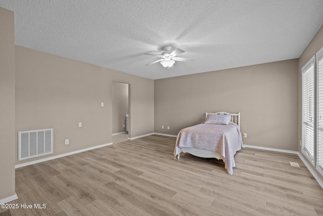 806 Lord Granville Dr, Morehead City, NC 28557 - bedroom featuring multiple windows, light wood-style flooring, and a textured ceiling