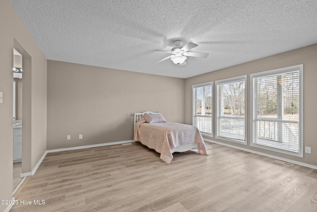 806 Lord Granville Dr, Morehead City, NC 28557 - bedroom with light wood-style flooring, a textured ceiling, baseboards, and ceiling fan