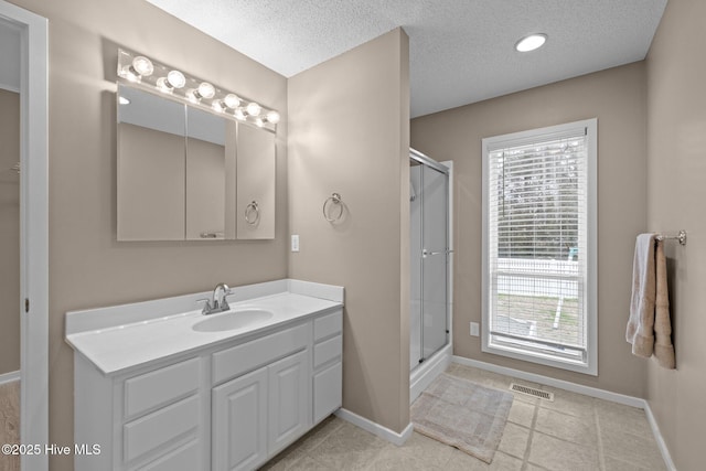 806 Lord Granville Dr, Morehead City, NC 28557 - full bath with a stall shower, baseboards, a textured ceiling, vanity, and tile patterned floors