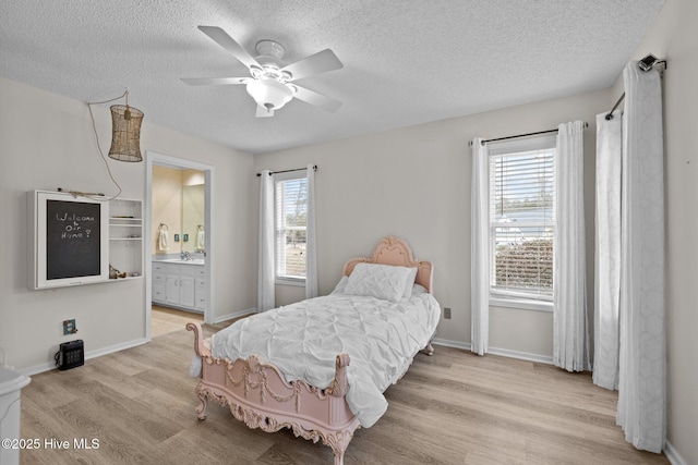 806 Lord Granville Dr, Morehead City, NC 28557 - bedroom with multiple windows, a textured ceiling, wood finished floors, ensuite bathroom, and baseboards