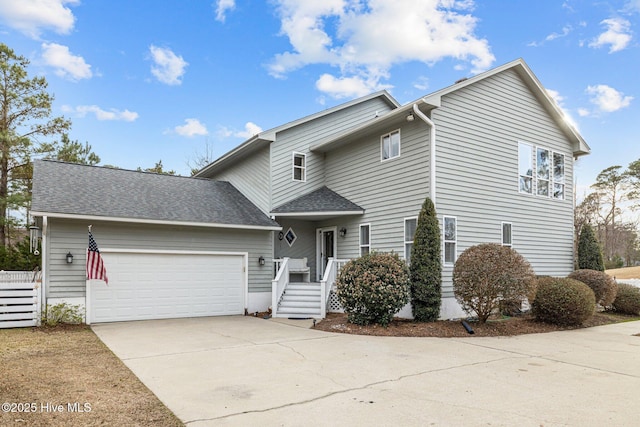 traditional-style house with a shingled roof, concrete driveway, and an attached garage