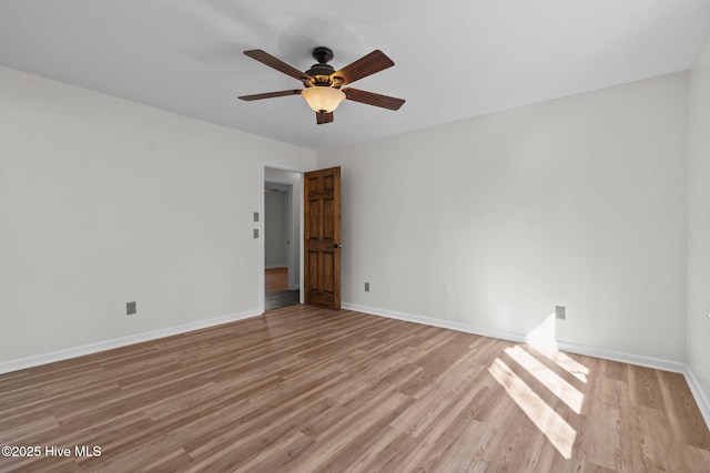 empty room with baseboards, ceiling fan, and light wood-style floors