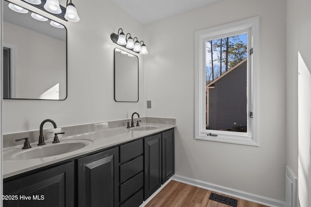 full bathroom featuring double vanity, wood finished floors, a sink, and visible vents