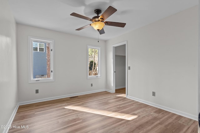 unfurnished bedroom with visible vents, light wood-style flooring, baseboards, and a spacious closet