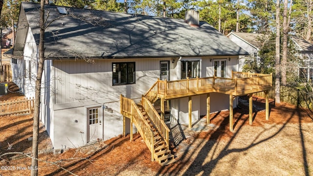 back of property featuring cooling unit, a shingled roof, stairs, a wooden deck, and a chimney