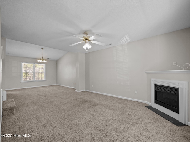 unfurnished living room featuring ceiling fan with notable chandelier, carpet floors, a textured ceiling, and vaulted ceiling