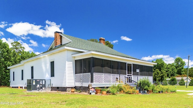 view of property exterior with a sunroom, a yard, and central AC