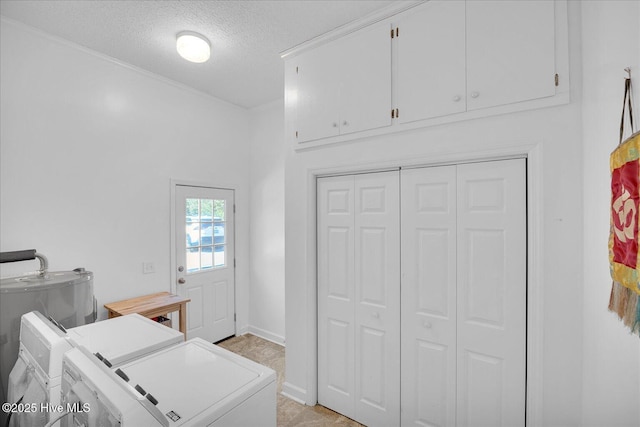 laundry area featuring cabinet space, a textured ceiling, baseboards, and separate washer and dryer